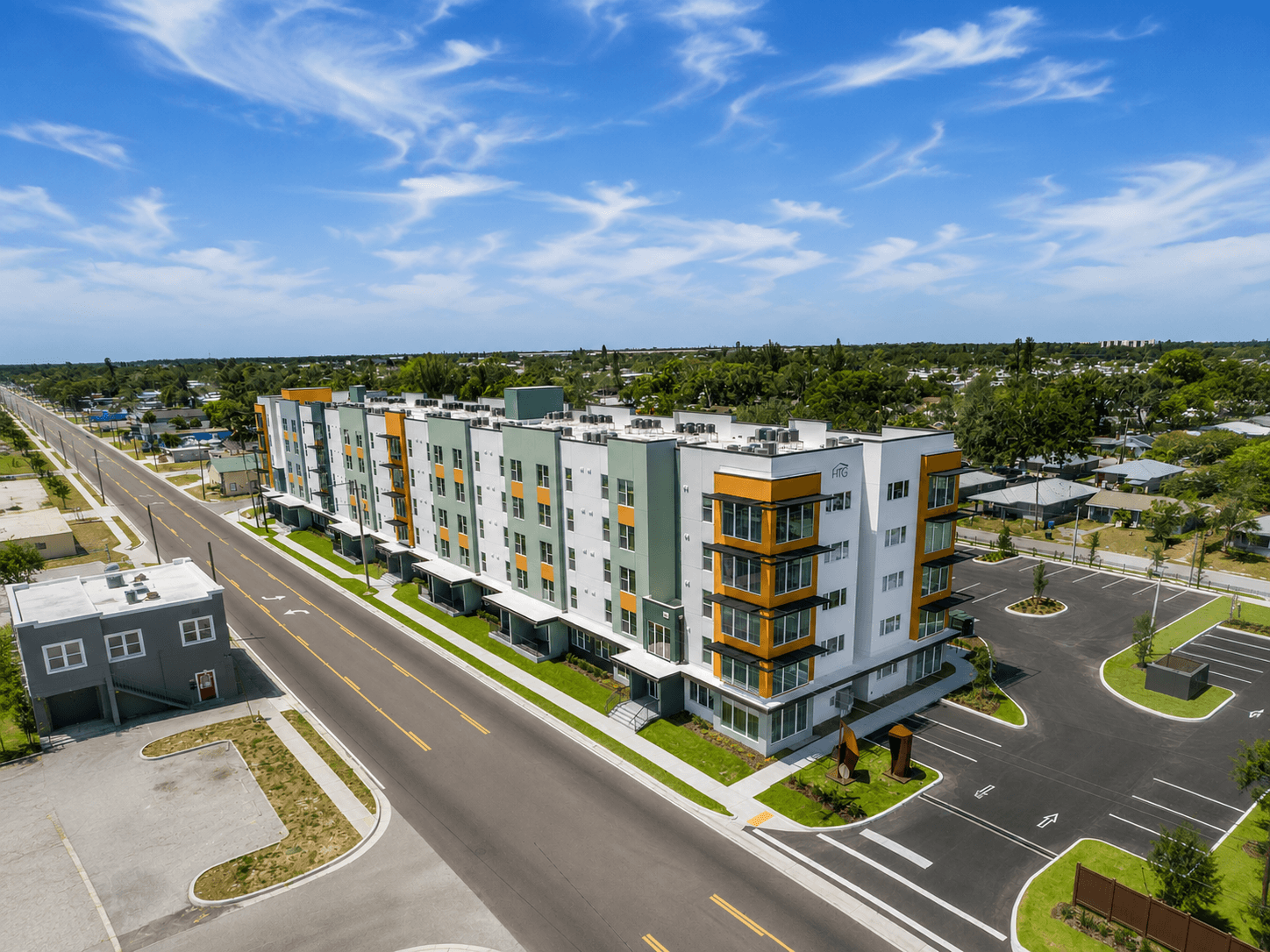 A modern apartment building with a parking lot in front.
